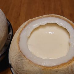 A picture of Steamed milk pudding in white coconut shell.
