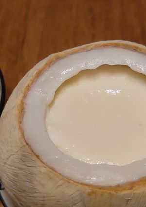 A picture of Steamed milk pudding in white coconut shell.