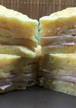 Una foto de Tortilla de patatas rellena de jamón y queso