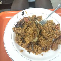 A picture of Jollof rice with basil and rosemary herbs.