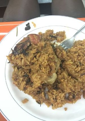 A picture of Jollof rice with basil and rosemary herbs.
