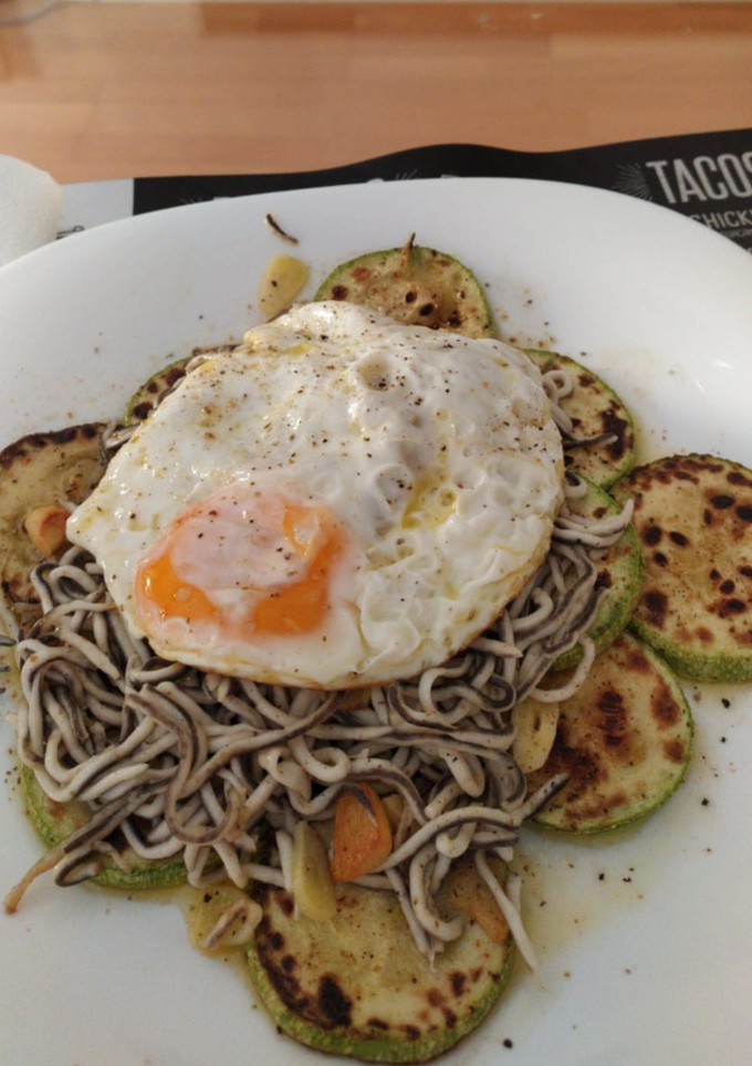 Una foto de Calabacín a la plancha con gulas y huevo