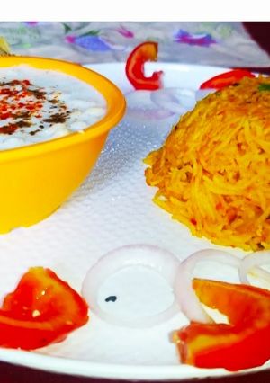 A picture of Tomato Rice with boondi Raita.