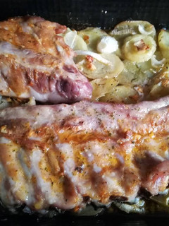 Una foto de Costillas con cama de patatas y cebolla