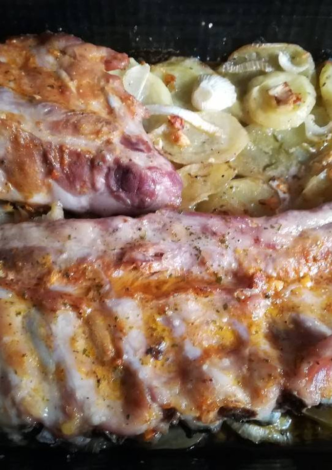 Una foto de Costillas con cama de patatas y cebolla