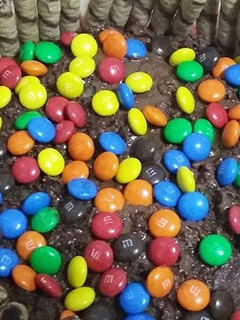 A picture of Nutella cake with M&M and wafers biscuit.