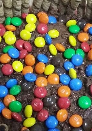 A picture of Nutella cake with M&M and wafers biscuit.