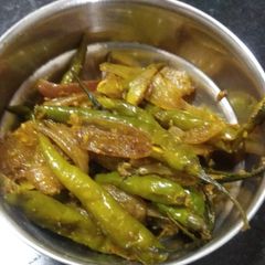 A picture of Green chillies with onion masala.
