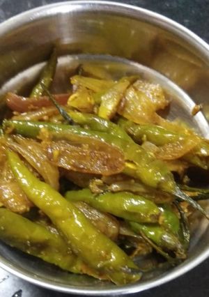 A picture of Green chillies with onion masala.