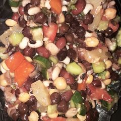 A picture of Veggies and fruits and beans and chickpea salad with lemon.