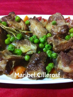 Una foto de Costilla de cerdo ibérico con cebollas, zanahorias y guisantes