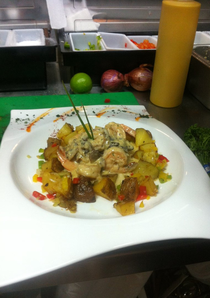 Una foto de Camarones salteados en crema de hongo y papas salteadas