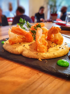 Una foto de Hummus con gambas fritas