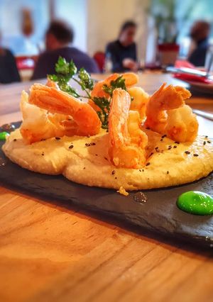 Una foto de Hummus con gambas fritas