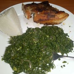A picture of Grilled chicken served with fried kales & ugali.