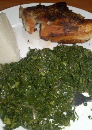 A picture of Grilled chicken served with fried kales & ugali.