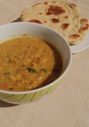 A picture of Naan bread with potato soup.