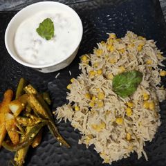 A picture of Chana Dal khichdi with boondi ratia and aloo bhindi.