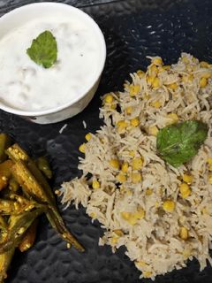 A picture of Chana Dal khichdi with boondi ratia and aloo bhindi.