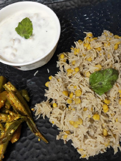 A picture of Chana Dal khichdi with boondi ratia and aloo bhindi.