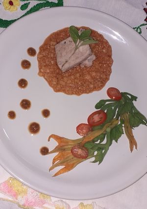 Una foto de Segueza de cerdo con ensalada de guías y flor de calabaza
