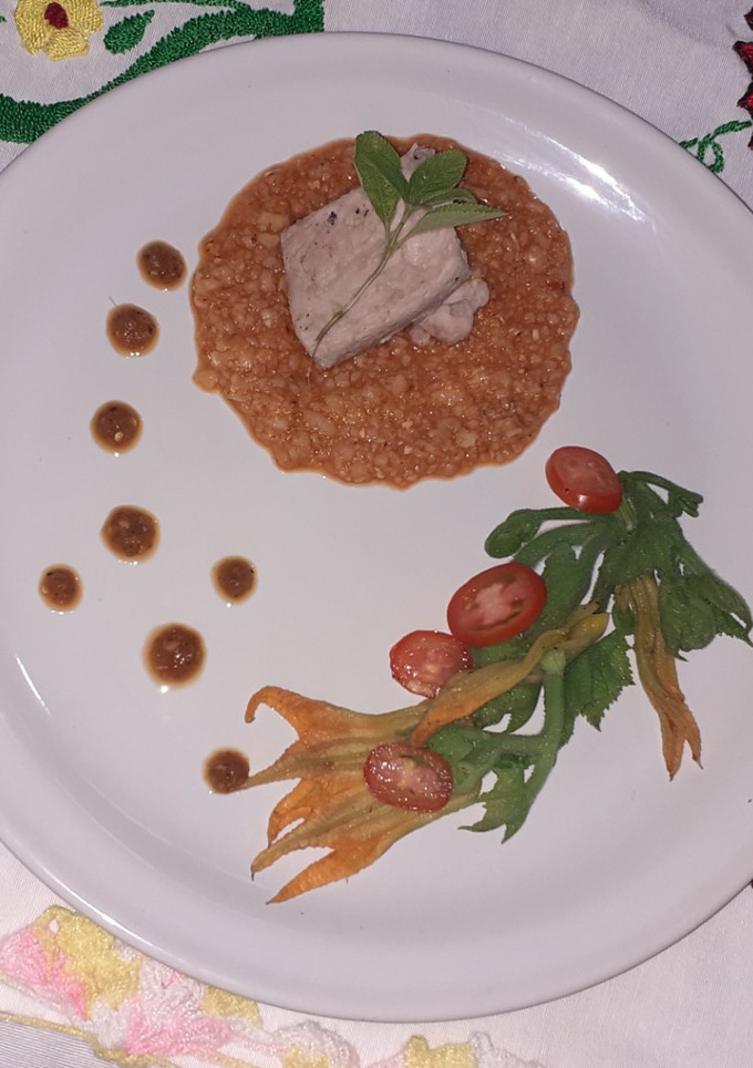 Una foto de Segueza de cerdo con ensalada de guías y flor de calabaza