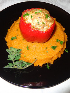 A picture of Red bell peppers stuffed with oregano chicken on sweet potatoes puree.