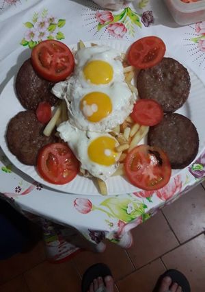 Una foto de Hamburguesa con papas huevos y tomate