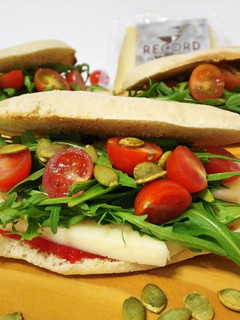 Una foto de Molletes con queso de oveja, rúcula, mermelada de pimiento y semillas
