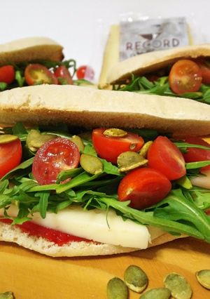 Una foto de Molletes con queso de oveja, rúcula, mermelada de pimiento y semillas