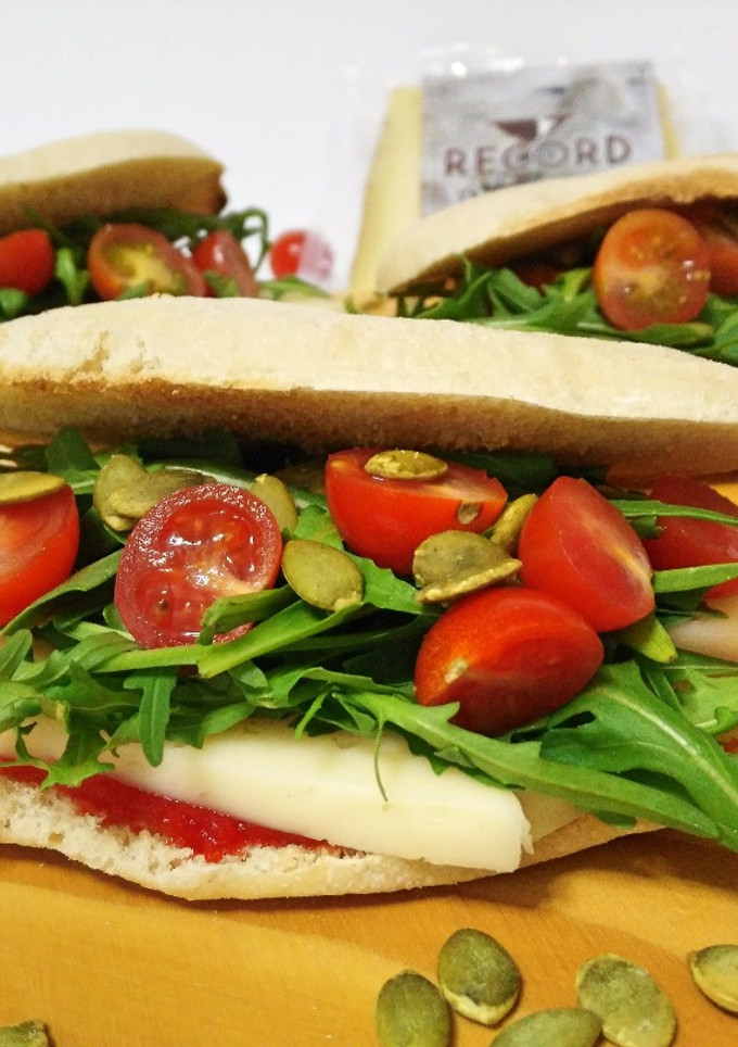 Una foto de Molletes con queso de oveja, rúcula, mermelada de pimiento y semillas