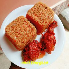 A picture of Jollof rice with sauced chicken 😋😋.