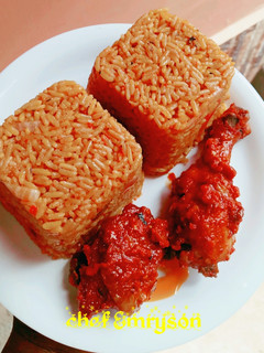 A picture of Jollof rice with sauced chicken 😋😋.