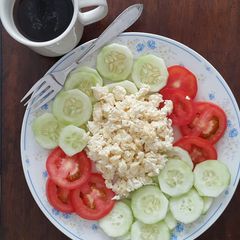 Scrambled eggs with tomato and cucumber salad A picture of Scrambled eggs with tomato and cucumber salad.
