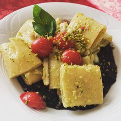 A picture of Pasta with black squid ink, squid and pistachio pesto.