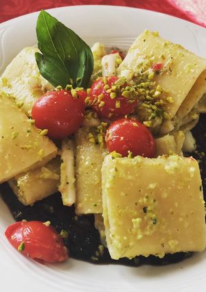 A picture of Pasta with black squid ink, squid and pistachio pesto.
