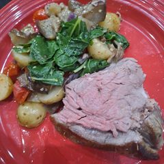 A picture of Leg of lamb, baked brinjals and potatoes.