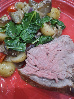 A picture of Leg of lamb, baked brinjals and potatoes.