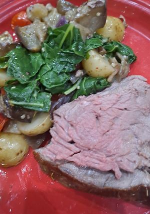 A picture of Leg of lamb, baked brinjals and potatoes.