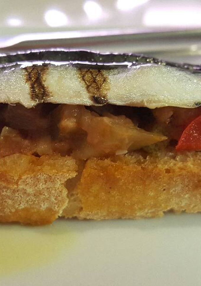 Una foto de Tostada de anchoas con tomate y pimiento