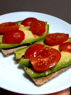 Una foto de Tostadas con aguacate, cherrys y limón 🥑🍅🍋