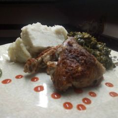 A picture of Fry chicken with greens accompanied by ugali.