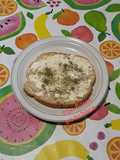 Tostada con frito de cebolla, polvo de flores y queso crema semi