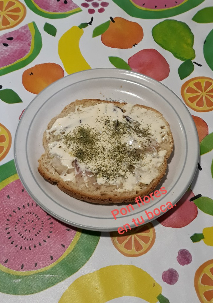 Una foto de Tostada con frito de cebolla, polvo de flores y queso crema semi