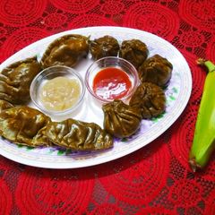 A picture of Steamed Green Momos with Raw Banana Filling.