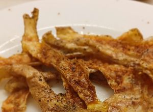Una foto de Crujientes de Piel de Patata Asada al Aroma de AOVE y Pimienta Negra