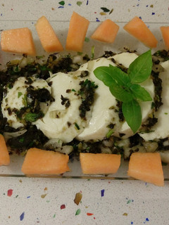 Una foto de Mozzarella aliñada con finas hierbas y aceitunas negras
