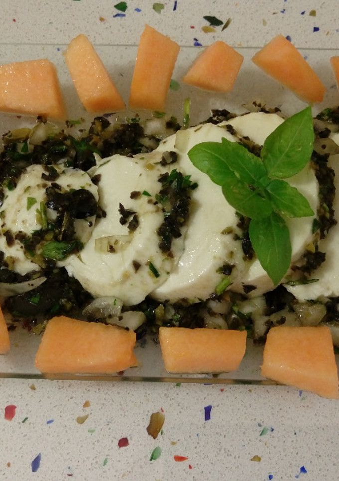 Una foto de Mozzarella aliñada con finas hierbas y aceitunas negras