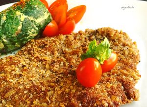 Una foto de Milanesas estilo peruanas a la chapa con buñuelos de acelga y tomates cherrys