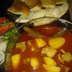 A picture of Aloo gosht with naan/taftan.